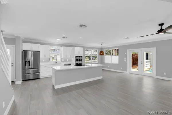 a large white kitchen with wooden floors and white walls