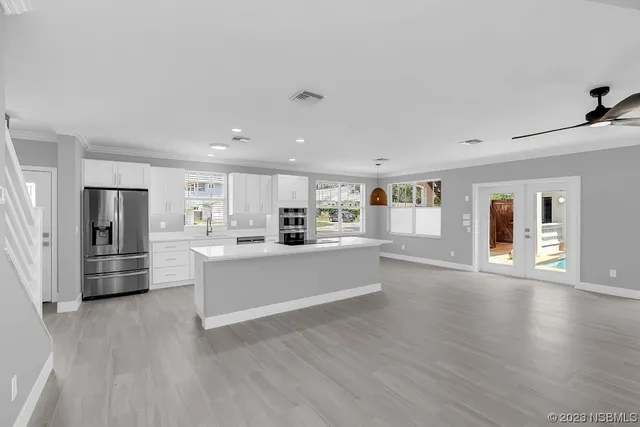 a large white kitchen with wooden floors and white walls