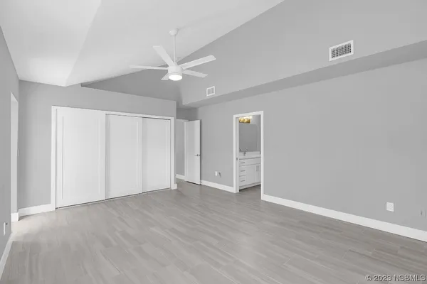 a spacious bathroom with a toilet a double vanity sink and mirror