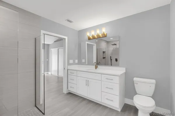 a bathroom with a toilet a sink a shower and mirror