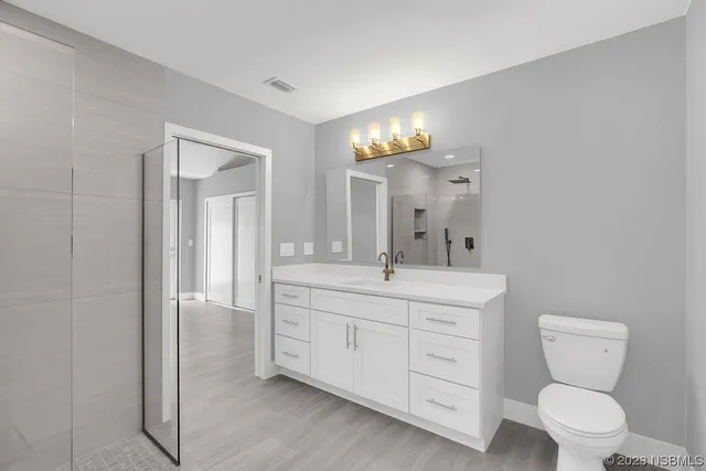 a bathroom with a toilet a sink a shower and mirror