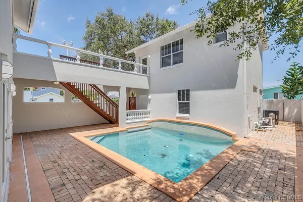 an aerial view of a house with garden space and a swimming pool