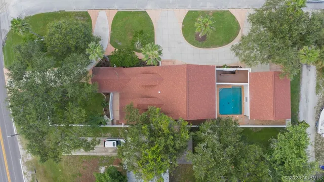 a aerial view of a house with a yard and a fountain
