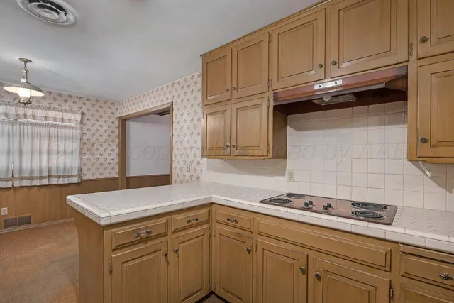 a kitchen with granite countertop cabinets and white appliances
