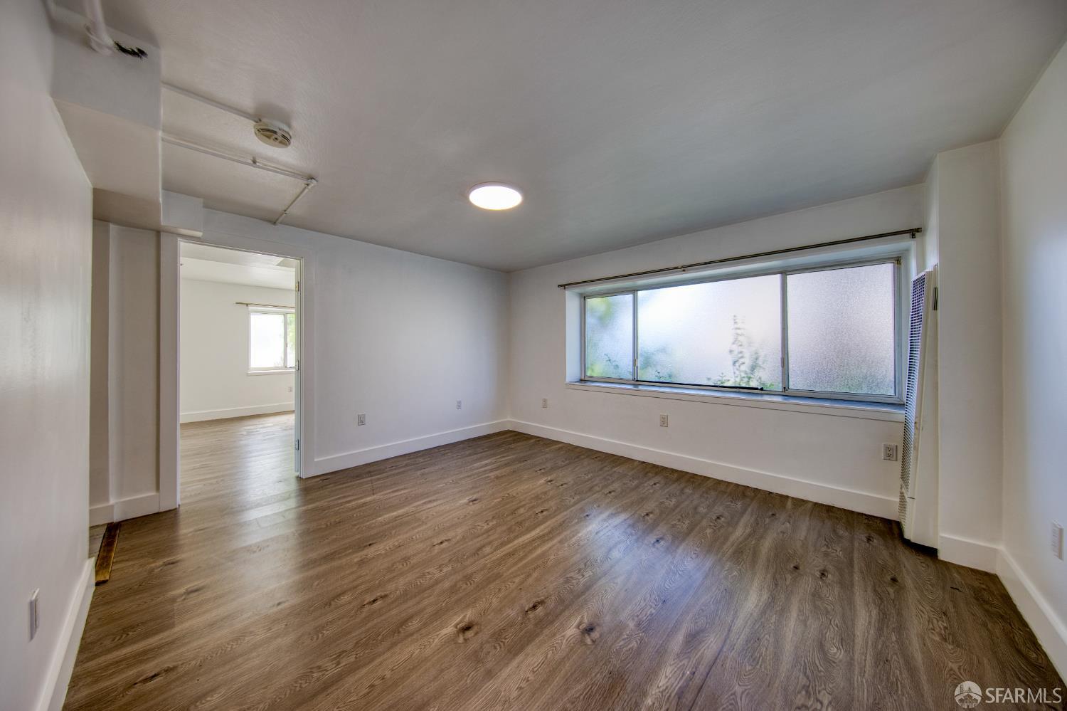 40 Irving Street San Francisco, CA 94122 - Photo 7 of 13 an empty room with wooden floor and windows