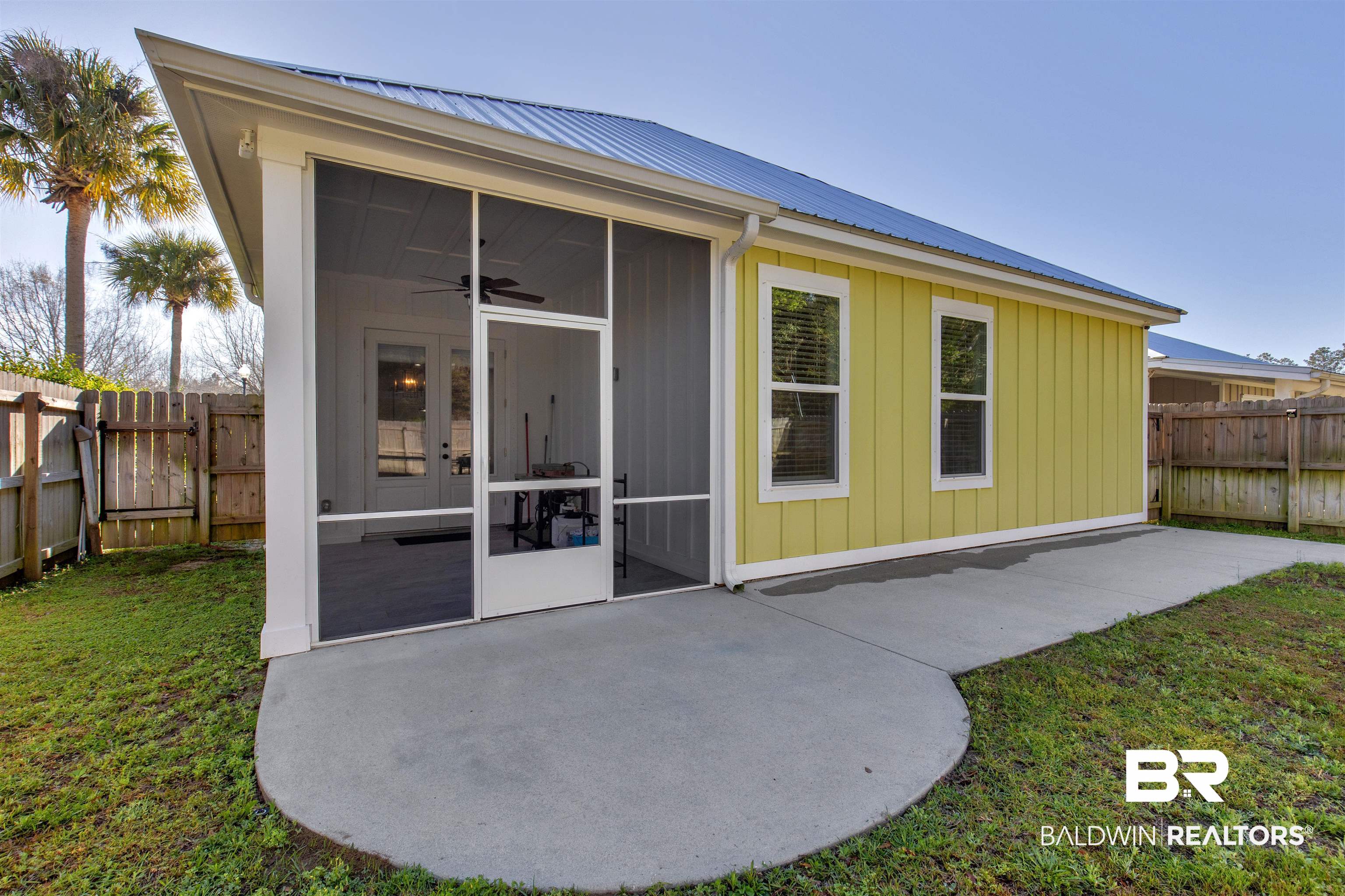 8069 Carmel Circle Foley, AL 36535 - Photo 20 of 23 Rear view of property with a fenced backyard, metal roof, a sunroom, and a patio