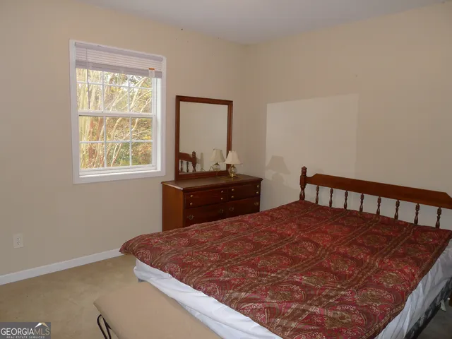 a bedroom with a bed and two windows