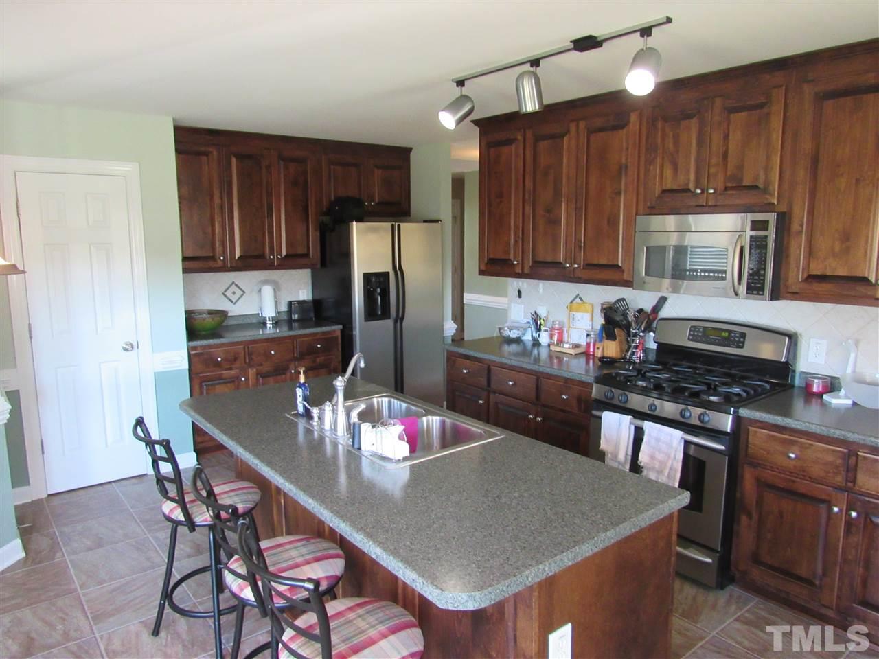 279 Steve Ridge Willow Spring, NC 27592 - Photo 8 of 25 a kitchen with stainless steel appliances granite countertop a stove top oven a refrigerator a sink and dishwasher