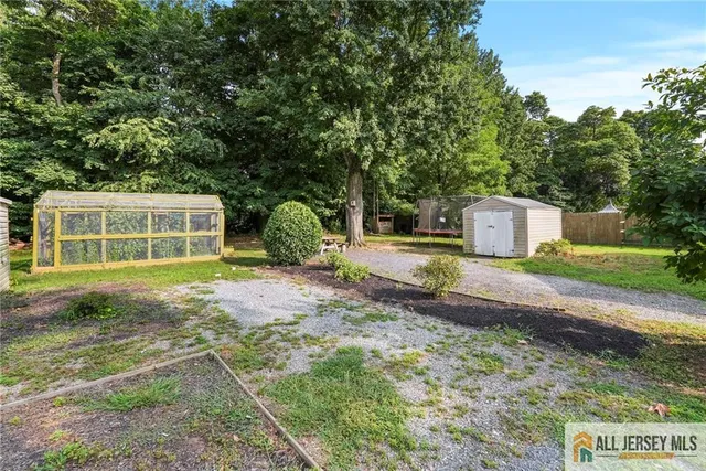 a view of a house with backyard and a tree
