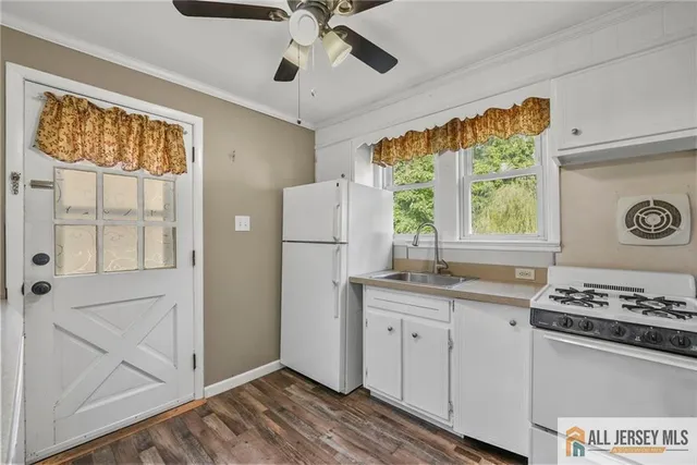 a kitchen with a refrigerator a stove cabinets and a window