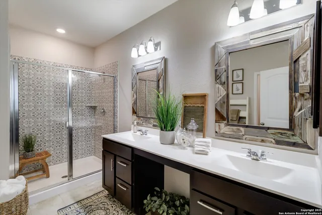 a bathroom with a double vanity sink a mirror and a shower