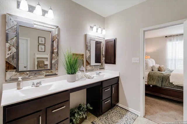 a en suite bathroom with double vanity and a mirror