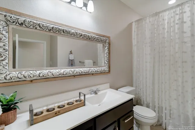 a bathroom with a sink a toilet and a mirror