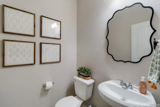a bathroom with a toilet sink and mirror