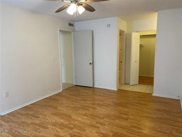 a view of an empty room with wooden floor
