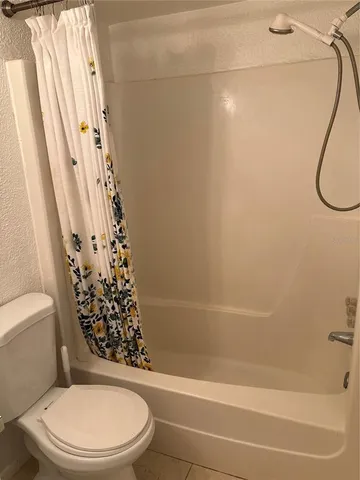 a white toilet sitting next to a bath tub and shower