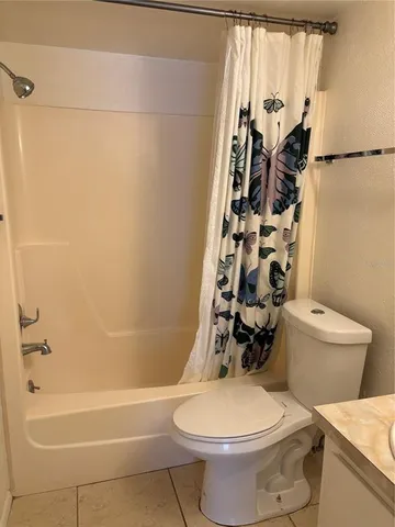 a white toilet sitting next to a bath tub