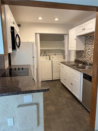 a kitchen with a sink stove and cabinets