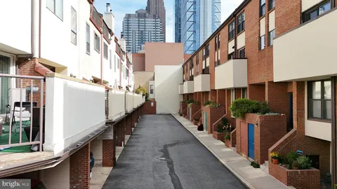 a view of a tall building with a couple of cars parked in front of it