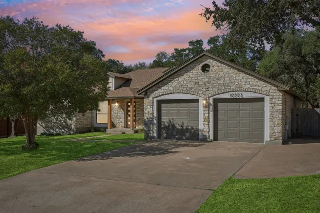a front view of a house with a yard and trees