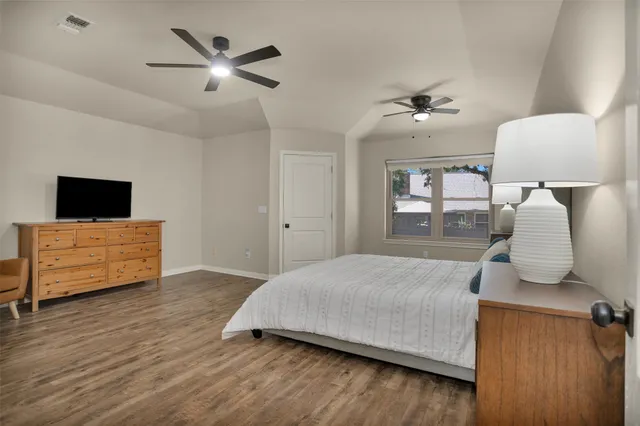 a bedroom with a bed and wooden floor