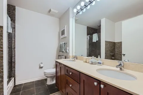 a bathroom with a double vanity sink toilet and a mirror