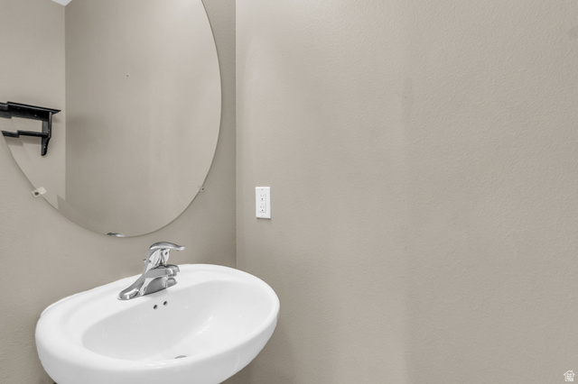 656 South 910 West, Unit 25 Pleasant Grove, UT 84062 - Photo 11 of 25 Pedestal sink with chrome-finish faucet and an oval wall mirror.