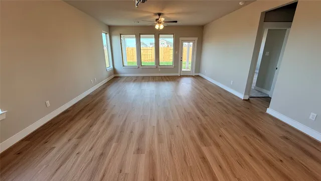 a large kitchen with stainless steel appliances granite countertop a sink a stove a refrigerator and island with wooden floor