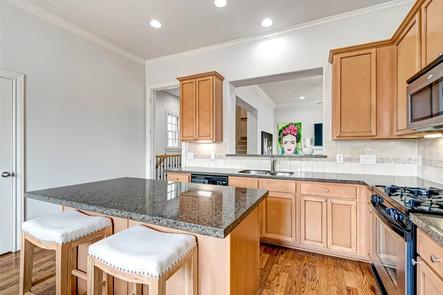a kitchen with granite countertop a center island stainless steel appliances cabinets and a counter top space