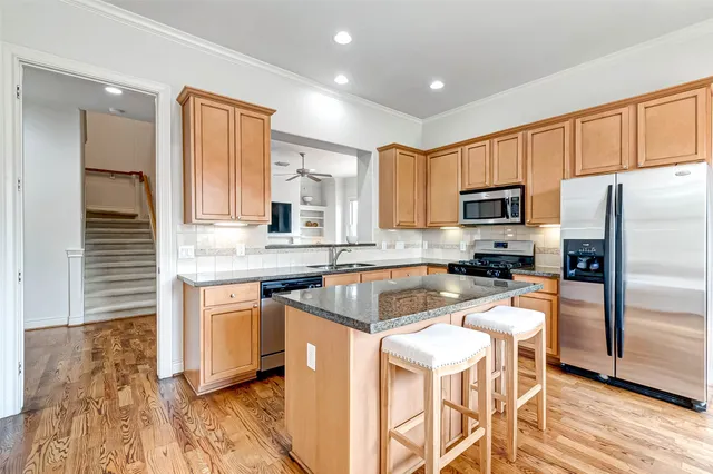 a kitchen with stainless steel appliances granite countertop a stove a sink and a microwave