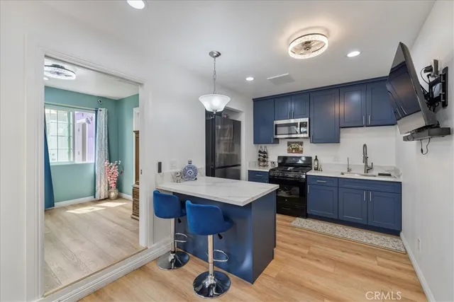 a kitchen with kitchen island a sink stainless steel appliances and cabinets