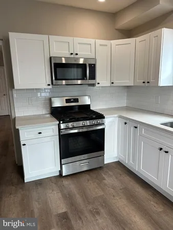 a kitchen with white cabinets and stainless steel appliances