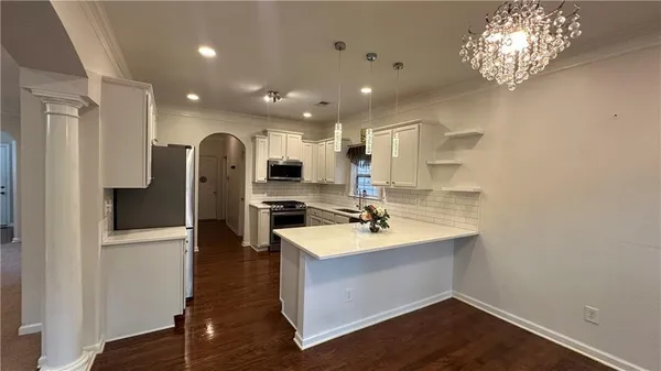 a kitchen with stainless steel appliances kitchen island granite countertop a refrigerator and a sink