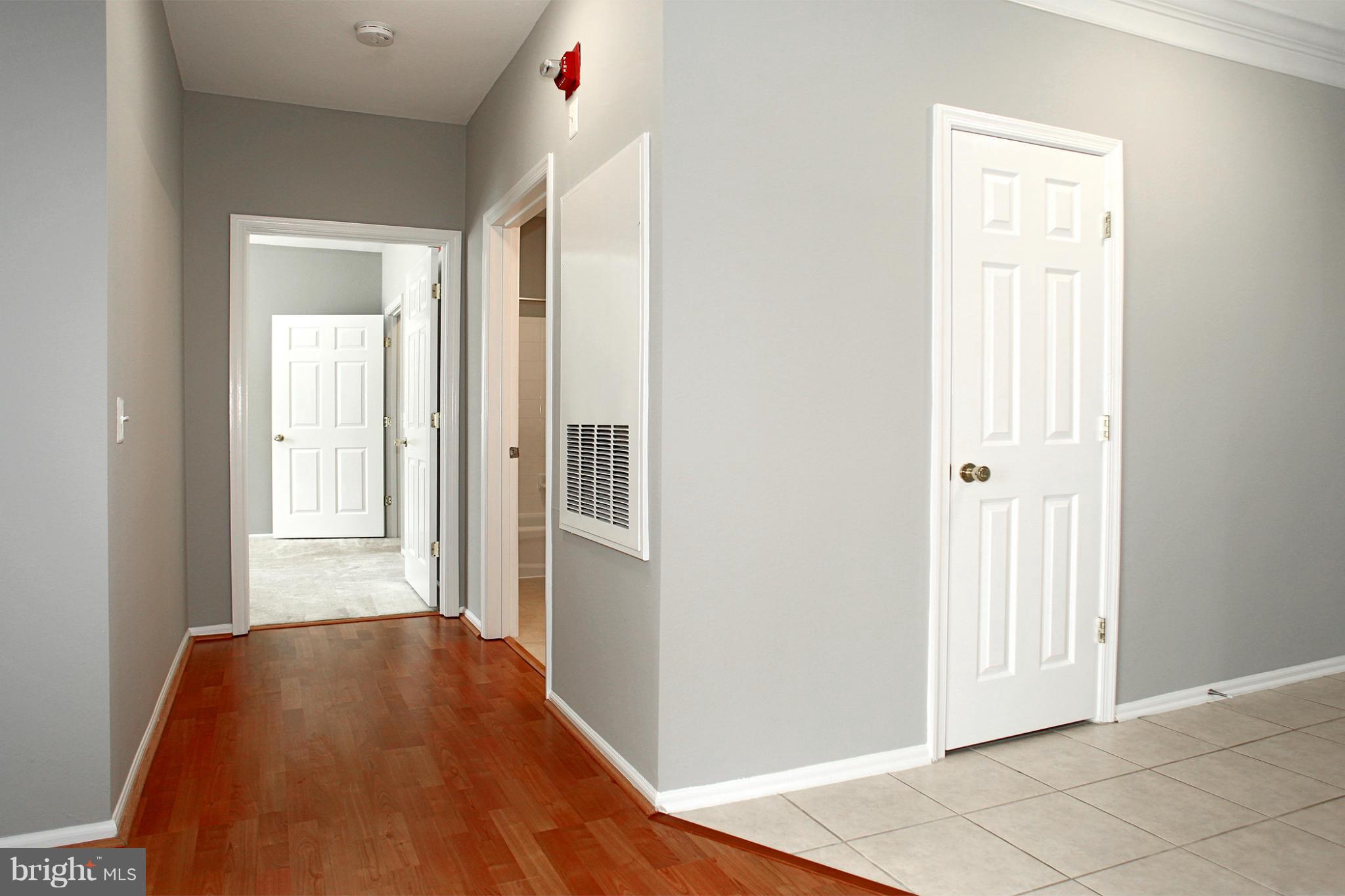 1530 Spring Gate Dr., Unit 9103 McLean, VA 22102 - Photo 18 of 30 a view of a hallway with wooden floor and a bathroom