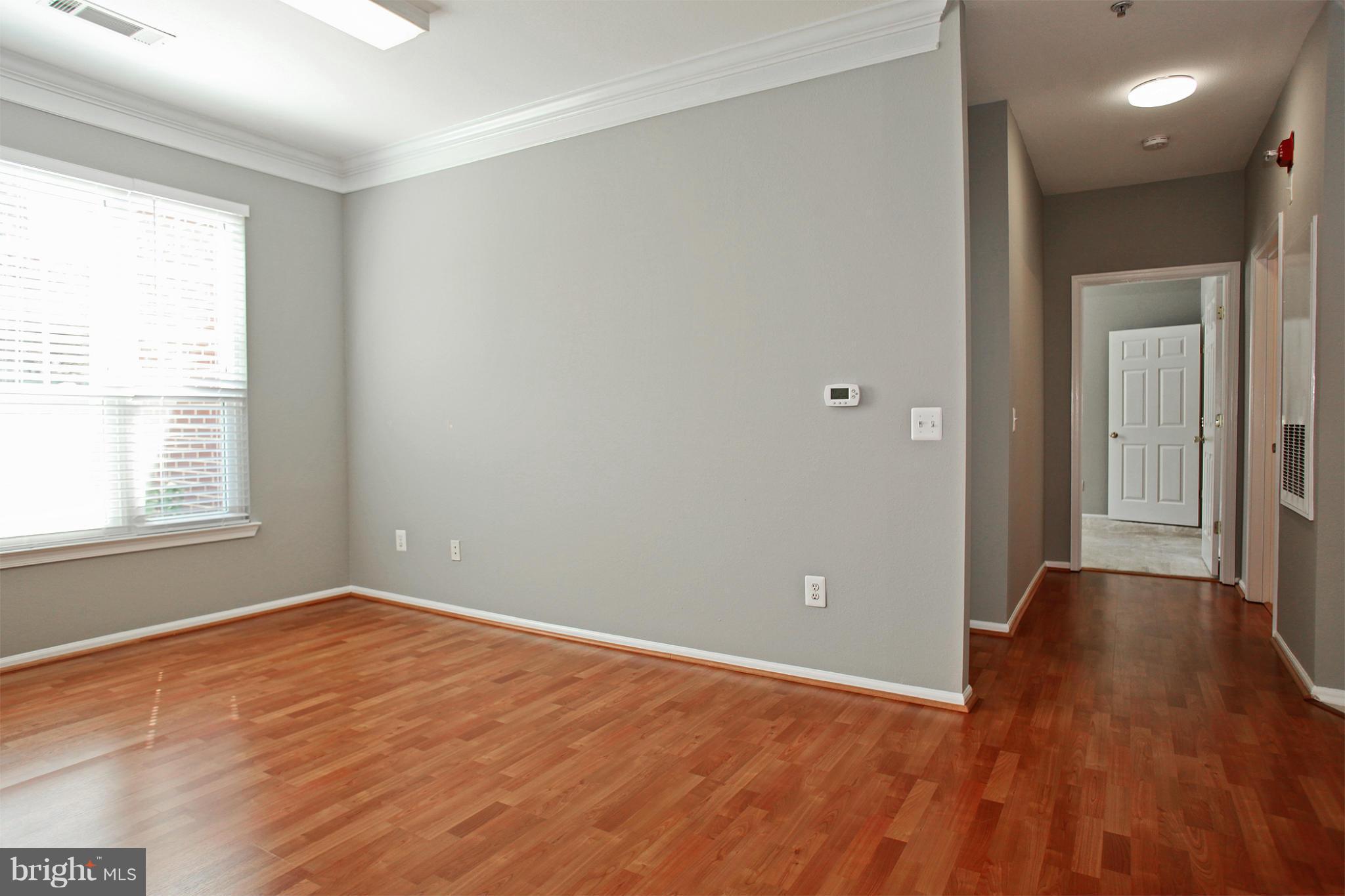 1530 Spring Gate Dr., Unit 9103 McLean, VA 22102 - Photo 19 of 30 wooden floor in an empty room with a window