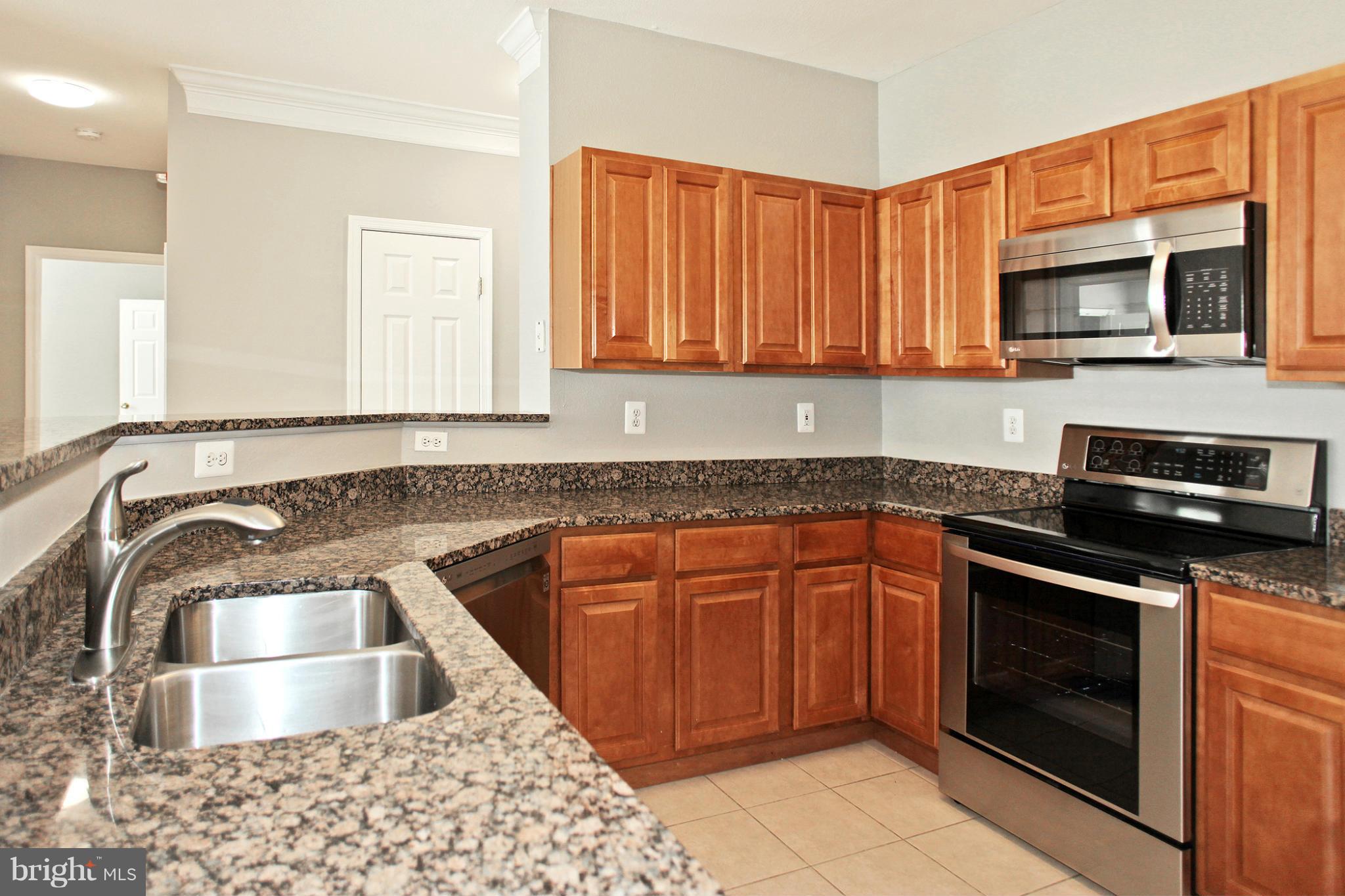 1530 Spring Gate Dr., Unit 9103 McLean, VA 22102 - Photo 5 of 30 a kitchen with stainless steel appliances granite countertop a sink stove and microwave
