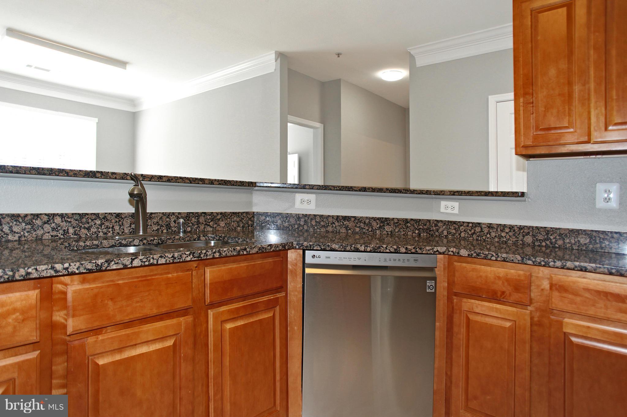 1530 Spring Gate Dr., Unit 9103 McLean, VA 22102 - Photo 6 of 30 a kitchen with granite countertop cabinets sink and wooden floor