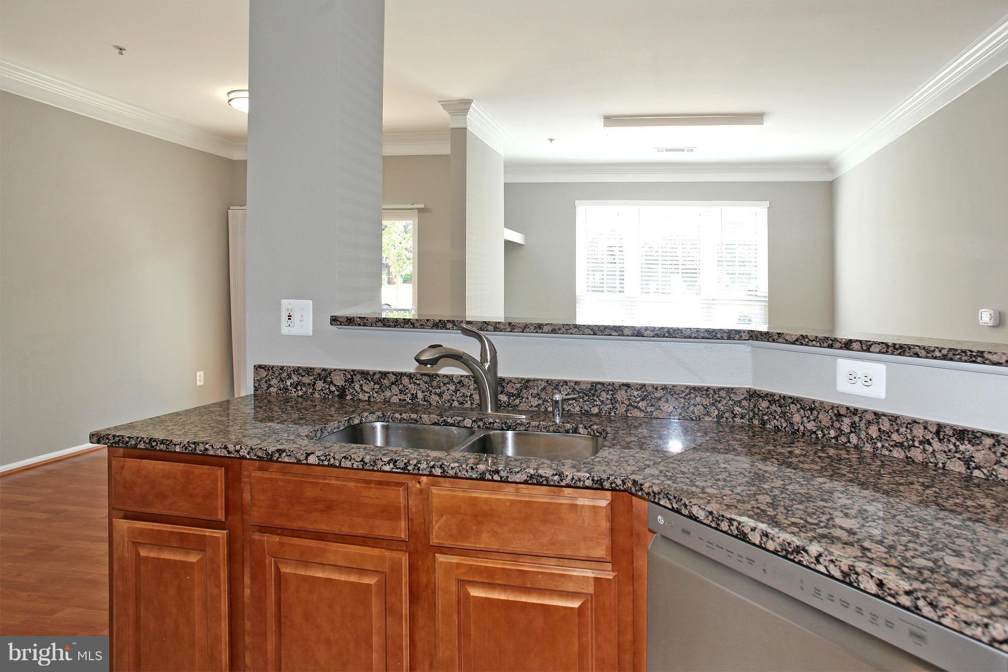 1530 Spring Gate Dr., Unit 9103 McLean, VA 22102 - Photo 7 of 30 a kitchen with granite countertop a sink and a white cabinets
