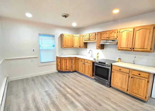 a large kitchen with stainless steel appliances granite countertop a sink and cabinets