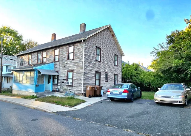 a front view of a house with cars parked
