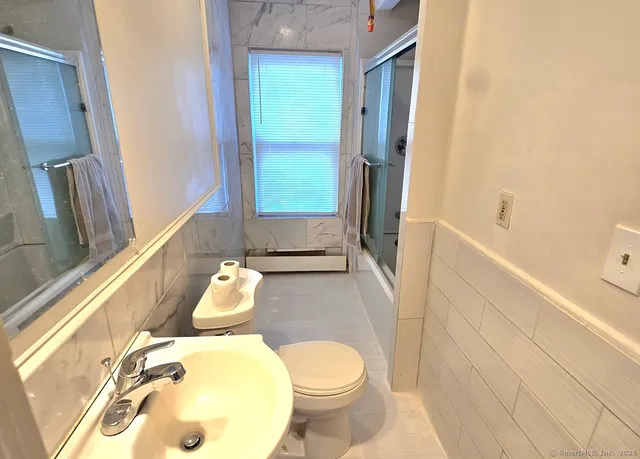 a bathroom with a sink and bathtub with toilet