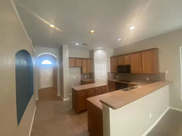 a kitchen with kitchen island a sink stainless steel appliances and cabinets