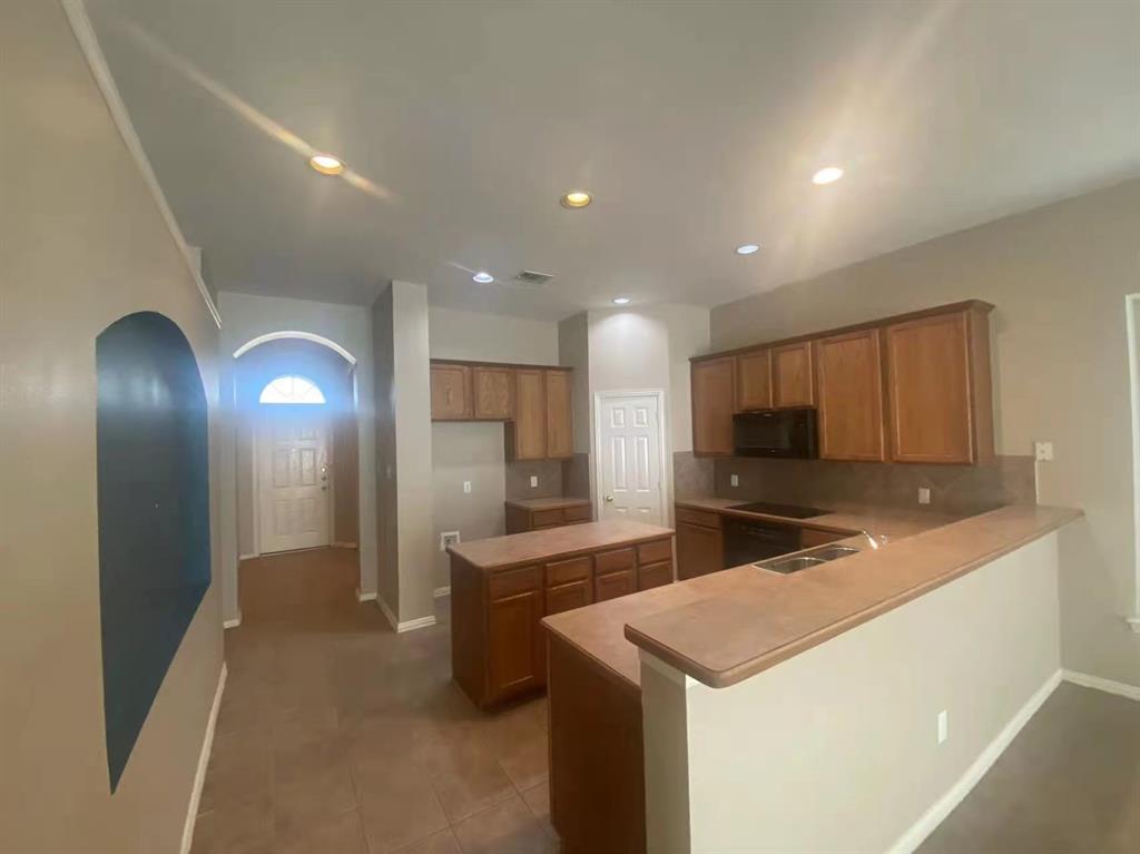 2363 Stuttgart Drive Frisco, TX 75033 - Photo 6 of 14 a kitchen with kitchen island a sink stainless steel appliances and cabinets