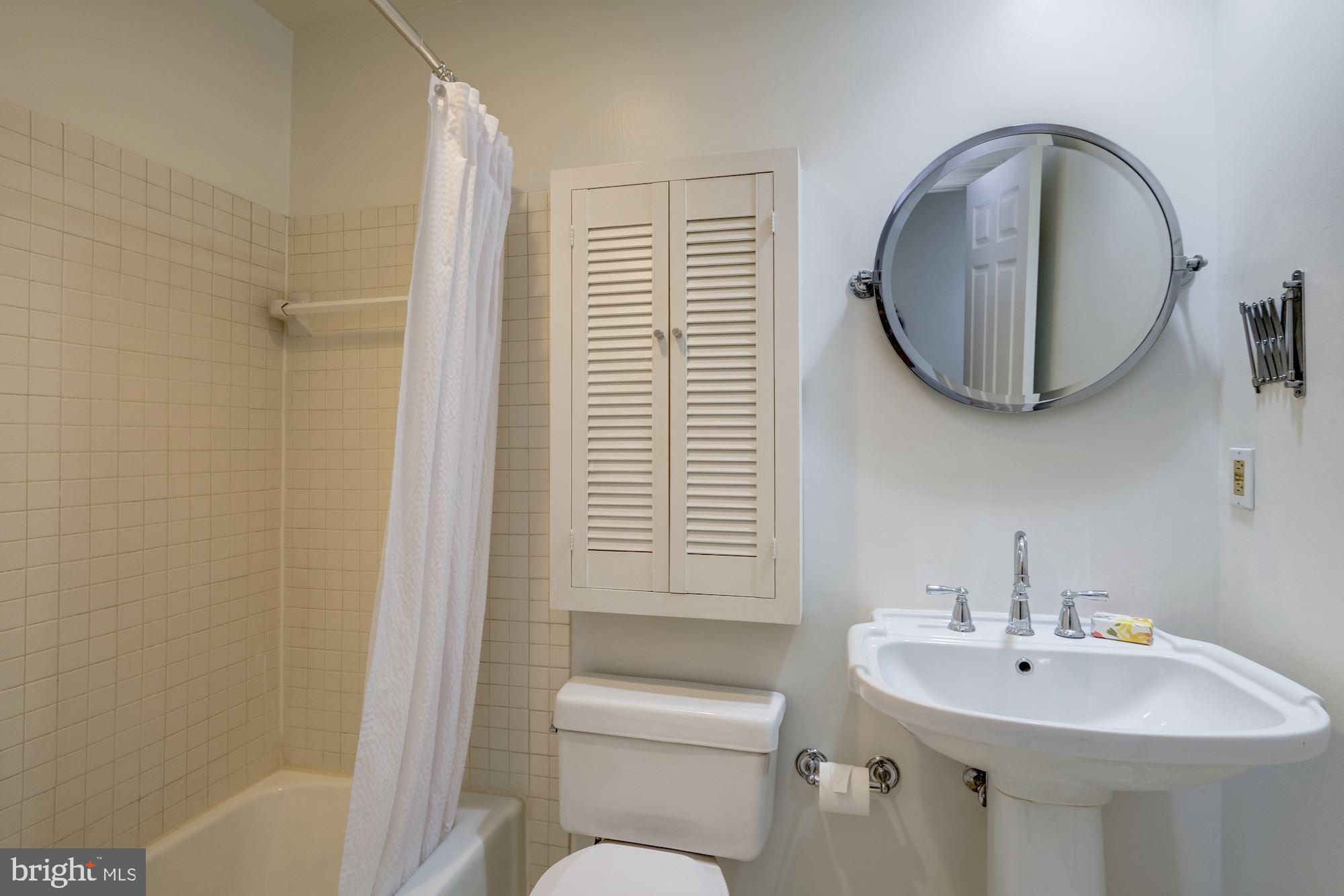 2153 California Street Northwest, Unit 306 Washington, DC 20008 - Photo 15 of 34 a bathroom with a sink a toilet and a mirror