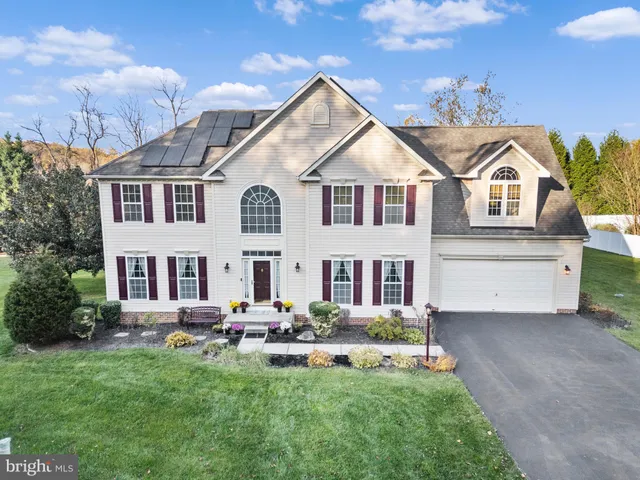 a front view of a house with swimming pool and chairs