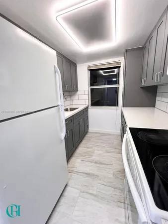 a kitchen with granite countertop a refrigerator and a stove top oven