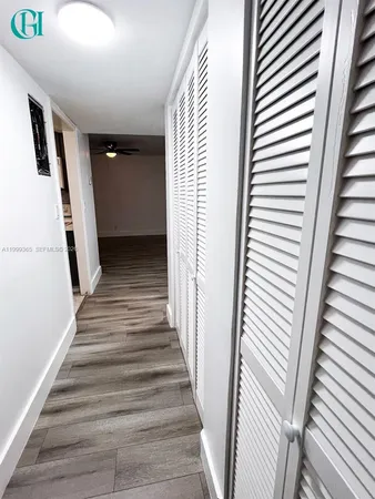 a view of a hallway with wooden floor and stairs