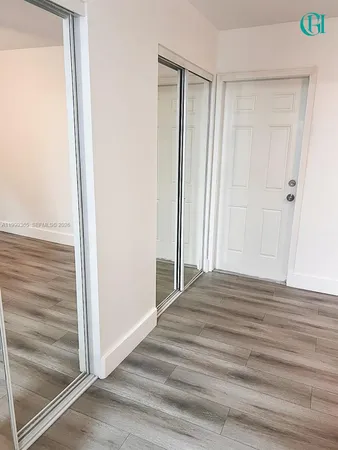 a view of a closet area with wooden floor