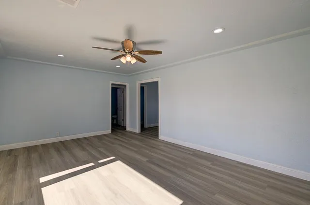 an empty room with a window and a fan
