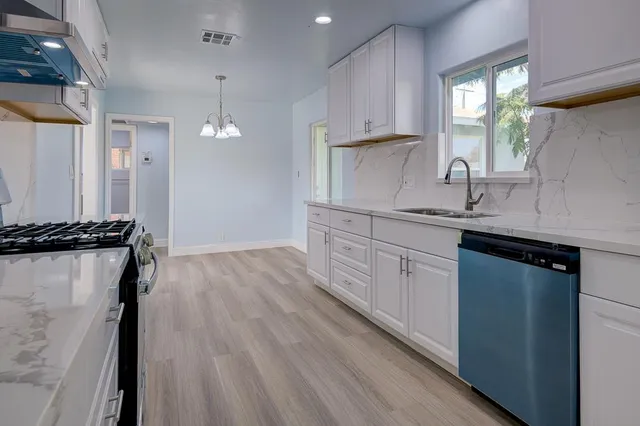 a kitchen with sink a stove and cabinets